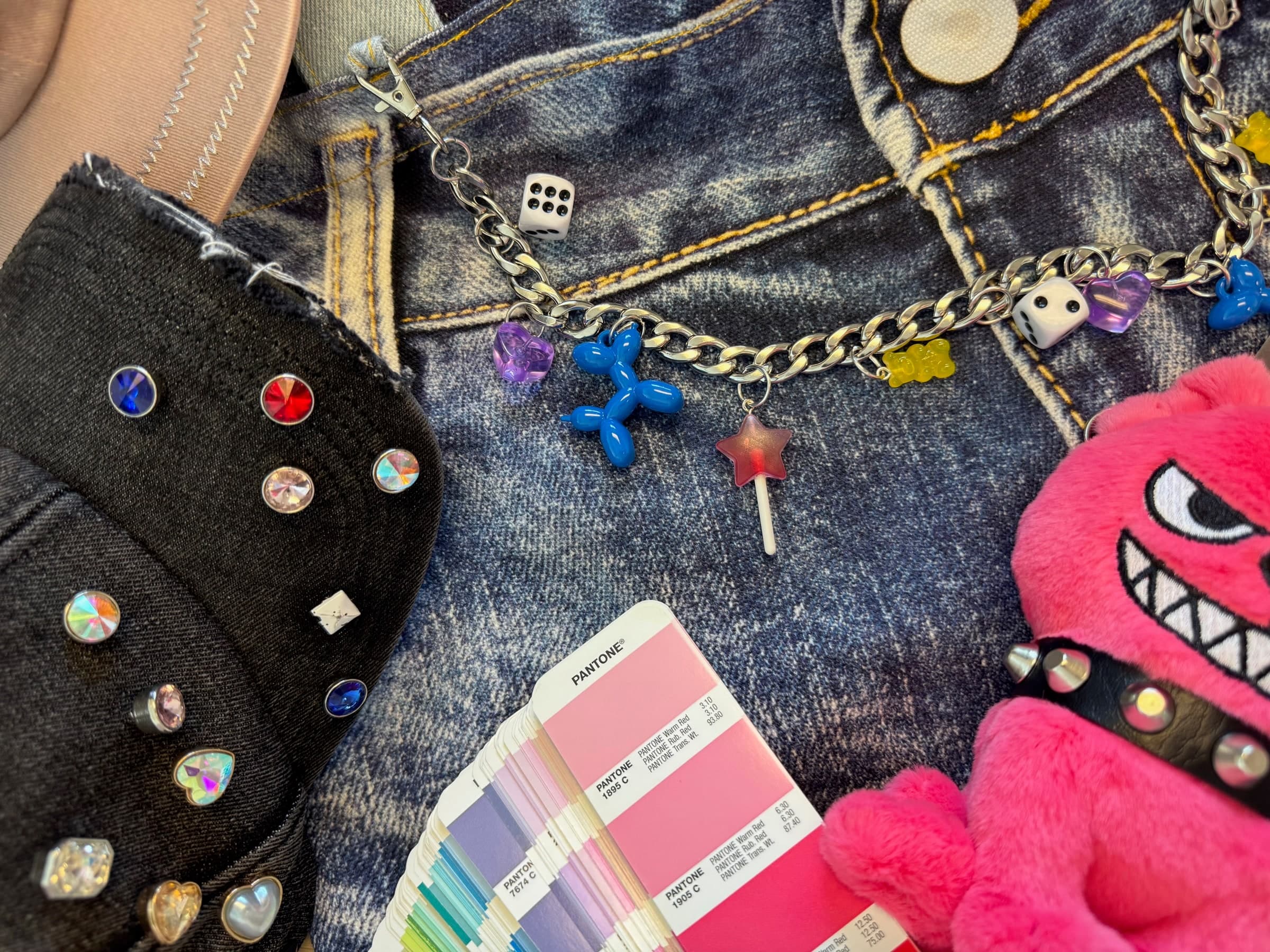 Charm chain sample staged on denim with Pantone swatch deck